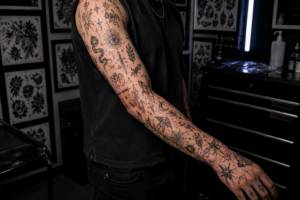 Realistic patchwork tattoo sleeve with curated collection of minimalist black ink tattoos