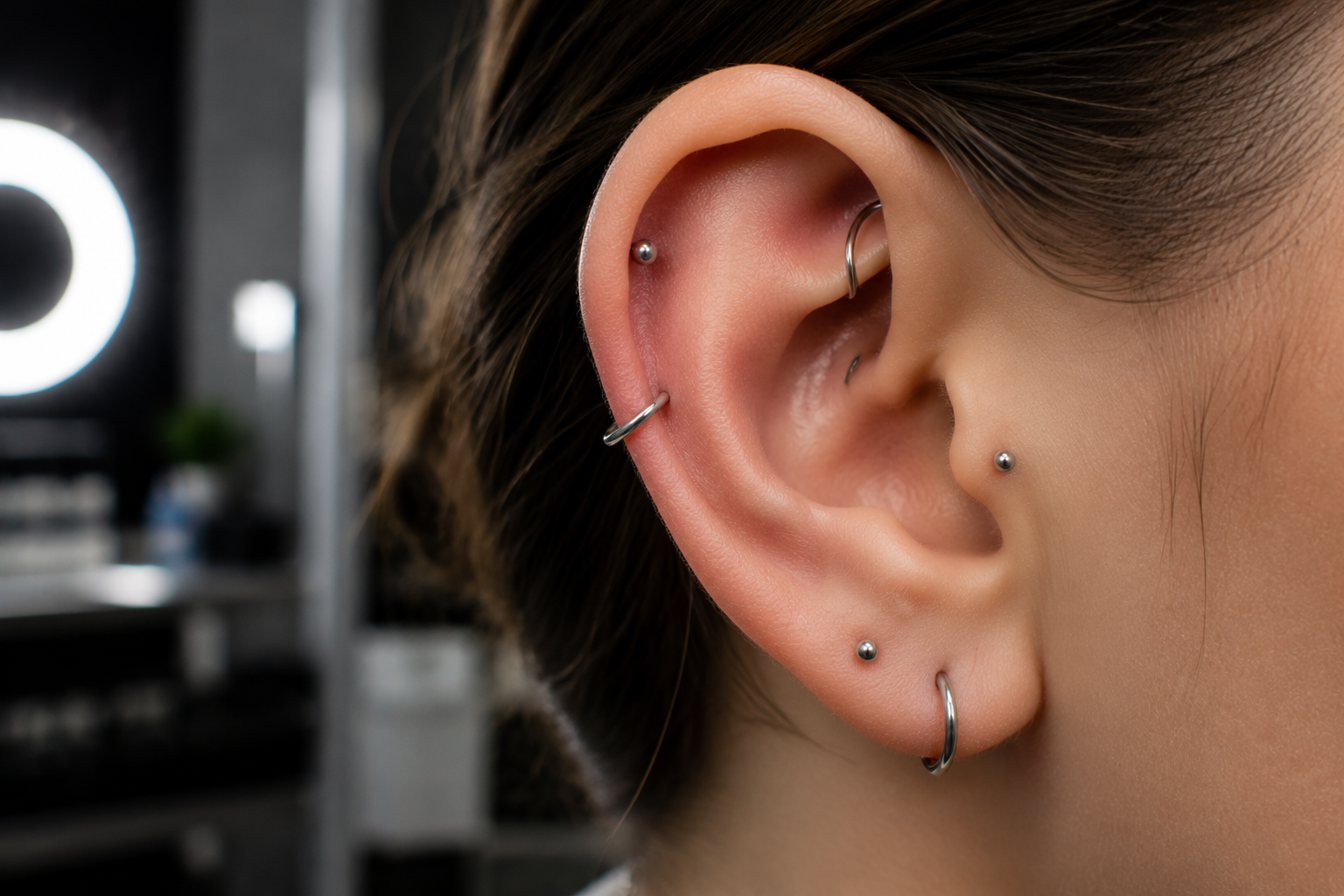Minimal surgical style piercing with seamless titanium jewelry in ear studio close-up