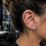 Realistic curated ear piercings with stacked lobe jewelry, helix hoops, and elegant silver studs