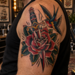 American Traditional tattoo with bold outlines and classic rose dagger and swallow imagery