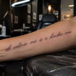 Custom handwritten script tattoo with elegant black ink lettering on forearm