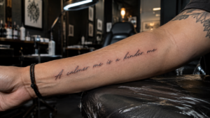 Custom handwritten script tattoo with elegant black ink lettering on forearm